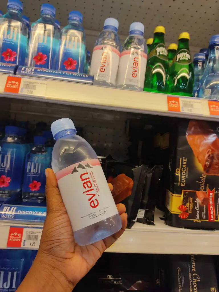 A person holding a evian bottled water in the supermarket