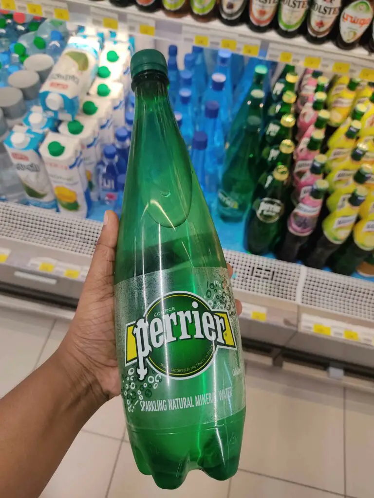A person holding a perrier bottled water in the supermarket